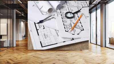 Different engineering drawings, dividers, pencil and magnifying glass on wooden table, closeup Wall mural