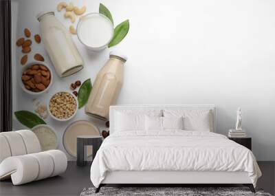 Different vegan milks and ingredients on white background, flat lay. Space for text Wall mural