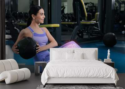 Digital composite of highlighted bones and woman exercising with medicine ball in gym Wall mural