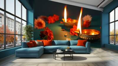 Diwali celebration. Diya lamps and beautiful flowers on teal table, closeup Wall mural