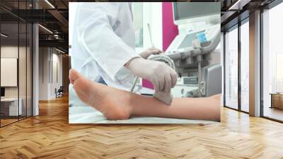 Doctor conducting ultrasound examination of patient's leg in clinic, closeup Wall mural