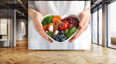 Doctor holding bowl with products for heart-healthy diet, closeup Wall mural