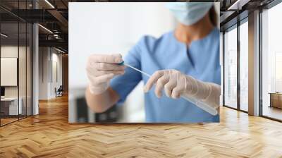 Doctor holding buccal cotton swab and tube for DNA test in clinic, closeup Wall mural