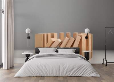 Domino effect. Wooden blocks falling on white table Wall mural