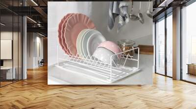 Drainer with different clean dishware on white table in kitchen Wall mural