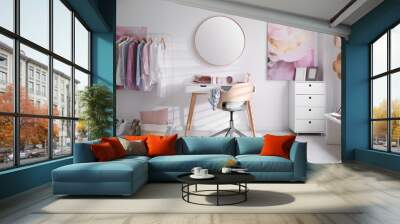 Dressing room interior with stylish makeup table, clothes and accessories Wall mural