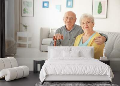 Elderly couple sitting on couch in living room Wall mural