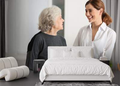 Elderly woman with female caregiver in room Wall mural