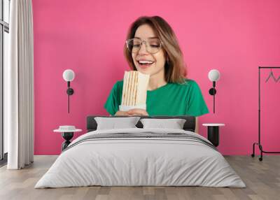 Emotional young woman with delicious shawarma on pink background Wall mural