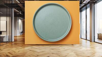 Empty ceramic plate on pale orange background, top view Wall mural