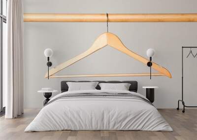 Empty clothes hanger on wooden rail against light grey background Wall mural