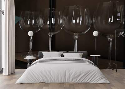 Empty wine glasses on shelf near brown wall Wall mural