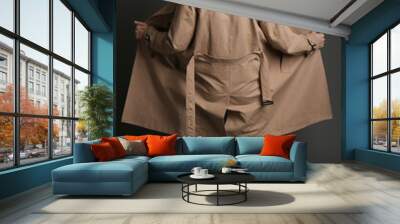 Exhibitionist exposing naked body under coat on black background, back view Wall mural