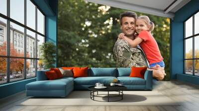 Father in military uniform holding his little daughter at green park Wall mural