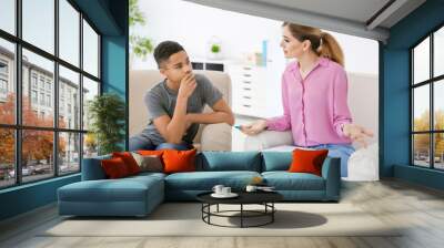 Female psychologist working with African American teenage boy in office Wall mural