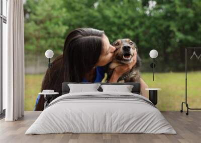 Female volunteer with homeless dog at animal shelter outdoors Wall mural