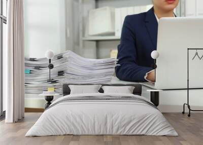 Female worker working with laptop near stack of documents in office, closeup Wall mural