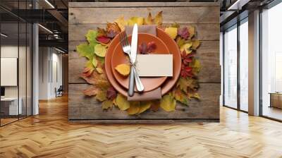 Festive table setting with autumn leaves and blank card on wooden background, flat lay Wall mural