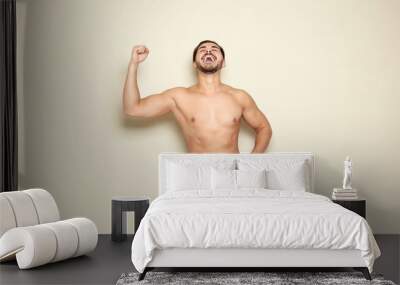 Fit man measuring his waist on color background. Weight loss Wall mural