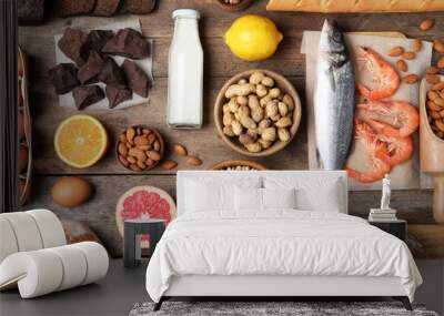 Flat lay composition of different products on wooden table. Food allergy concept Wall mural