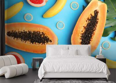 Flat lay composition with condoms and exotic fruits on blue background. Erotic concept Wall mural