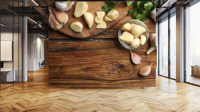 Flat lay composition with fresh garlic bulbs and cloves on wooden table, space for text. Organic product Wall mural