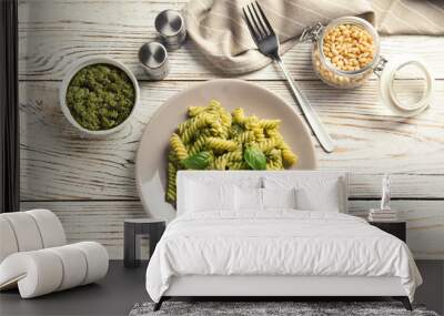 Flat lay composition with plate of delicious basil pesto pasta on wooden table Wall mural