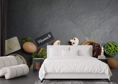 Flat lay composition with products rich in vitamin D on black table. Space for text Wall mural