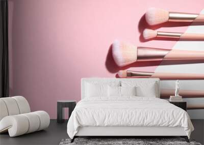 Flat lay composition with professional makeup brushes on color background. Space for text Wall mural