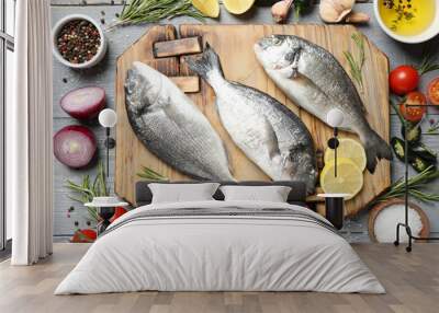 Flat lay composition with raw dorada fish on light grey wooden table Wall mural