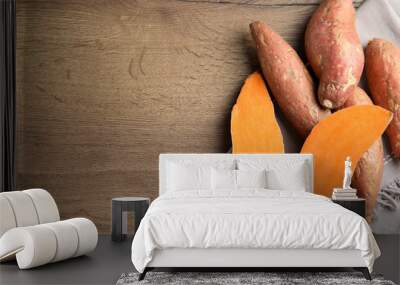 Flat lay composition with sweet potatoes and space for text on wooden background Wall mural