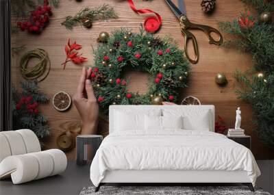 Florist making beautiful Christmas wreath at wooden table, top view Wall mural