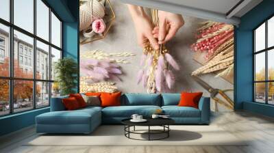 Florist making bouquet of dried flowers at grey stone table, top view Wall mural