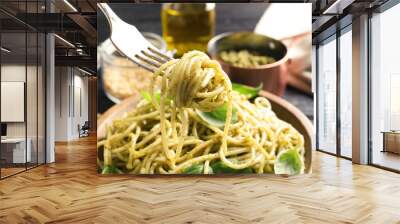 Fork with delicious basil pesto pasta over plate, closeup Wall mural