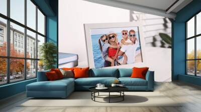 Frame with family photo on white table indoors, closeup Wall mural