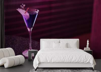 fresh alcoholic cocktail in glass on table against dark purple background. space for text Wall mural