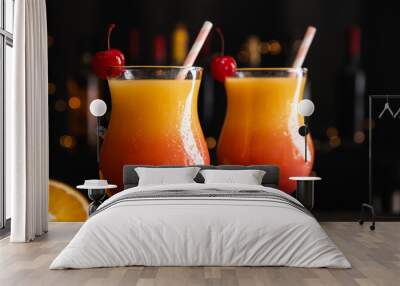 Fresh alcoholic Tequila Sunrise cocktails against blurred lights, closeup Wall mural