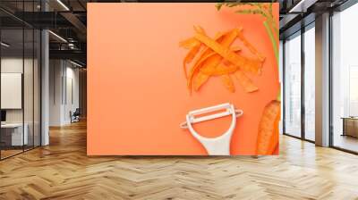 Fresh carrot, vegetable peeler and peels on orange background, flat lay. Space for text Wall mural