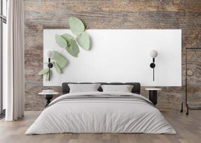 Fresh eucalyptus leaves and blank card with space for design on wooden background, top view Wall mural