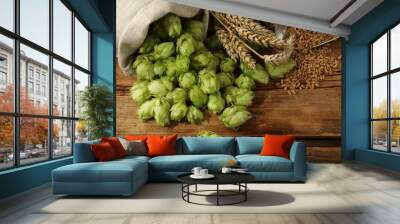 Fresh green hops, wheat grains and spikes on wooden table, flat lay Wall mural