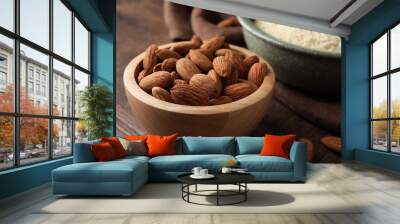 Fresh nuts and almond flour on wooden table, closeup Wall mural