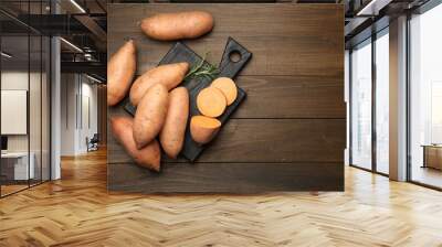 Fresh raw sweet potatoes and rosemary on wooden table, top view. Space for text Wall mural