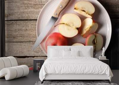 Fresh red apples, leaves and knife on wooden table, flat lay Wall mural