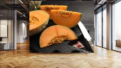 Fresh ripe Cantaloupe melons and knife on dark wooden table, closeup Wall mural