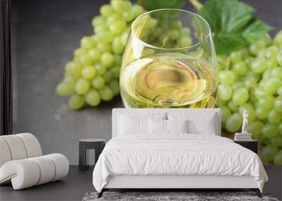 Fresh ripe grapes and glass of wine on grey table, closeup Wall mural