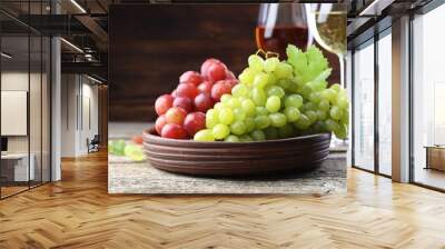 Fresh ripe grapes and glasses of wine on wooden table Wall mural