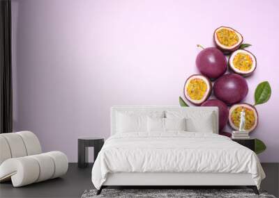 Fresh ripe passion fruits (maracuyas) with leaves on light pink background, flat lay. Space for text Wall mural