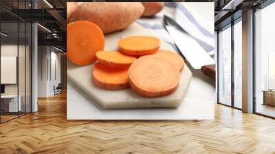 Fresh sweet potatoes, knife and kitchen towel on white table, closeup Wall mural