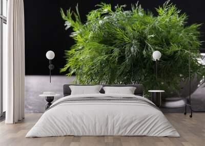 Fresh wet dill in colander on grey textured table against black background, closeup Wall mural