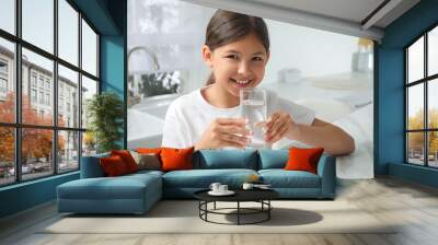 Girl drinking tap water from glass in kitchen Wall mural